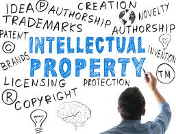 Man drawing on whiteboard words about brands and the sentence "Intellectual Property" at the center