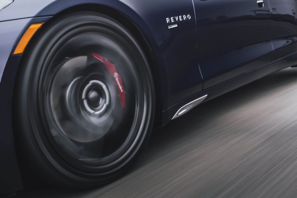 A closeup photo of the Karma Revero concept car tire spinning while the vehicle races down the road.