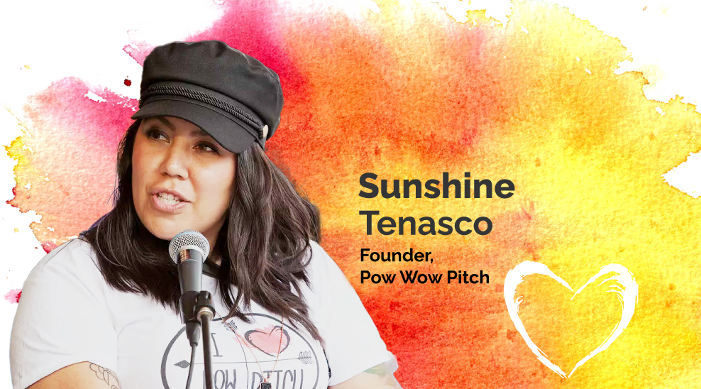 An image of Pow Pow Pitch Founder Sunshine Tenasco, speaking into a microphone wearing a white "I heart Pow Pow Pitch" t-shirt and a black hat. 