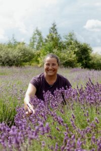 An image of Lavenbel founder Monia Otis sitting in a lavendar field - photo courtesy of Amanda Thirkill https://amandathirkill.ca/