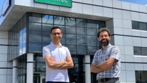 The founders of Giatec stand in front of the building with their arms crossed with pride. 