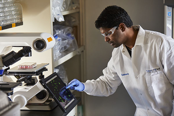 Worker with a lab coat on interacting with a machine